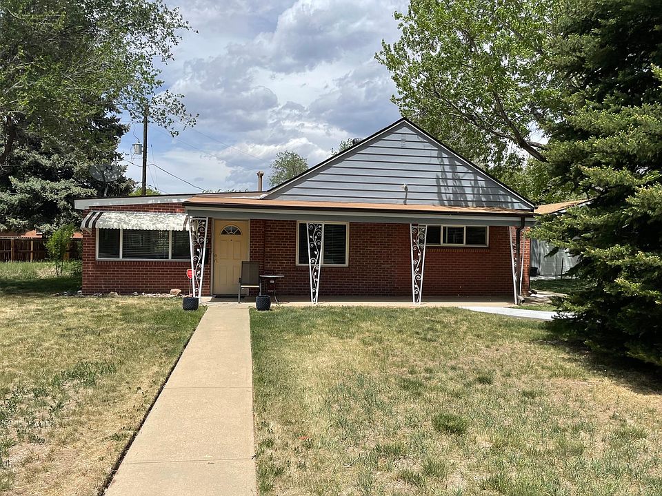 Exterior front of home with large yard and ample tree shade.