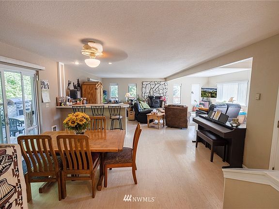 View of dining area from the kitchen, shows peninsula that easily accomadates 6 barstools, large dining area and door to stairs leading to basement and garage.  Large double paned sliding doors have a doggie door that can easily be removed or stay for your furry friend.  This leads out to a large deck that adds to your entertainment space.  Also fenced to contain dogs and people!