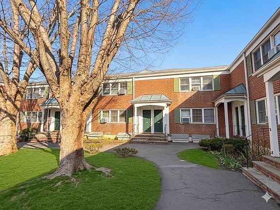 View of unit main entrance overlooking peaceful park-like courtyard.