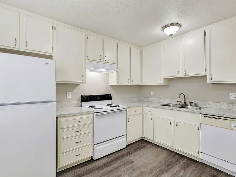 Lake Dianne Apartment Homes One Bedroom kitchen with white appliances and cabinets.