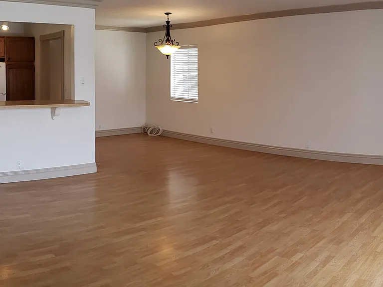 Wide angle view of living room, dining room, and kitchen.
