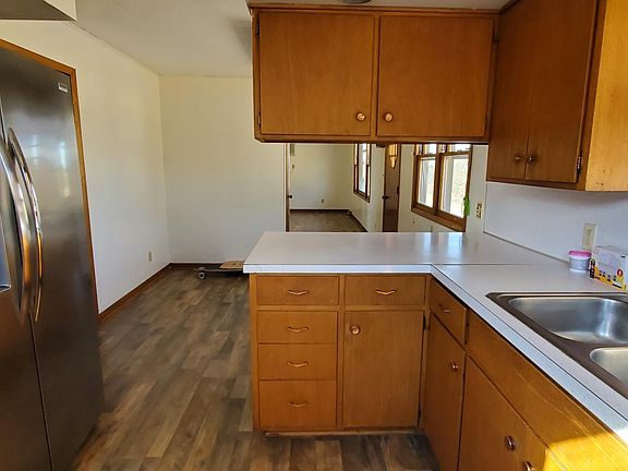 Facing north by the kitchen door, looking through the dining area and main living room
