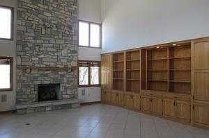 Living Room With Stone Fireplace And Built In Cabi