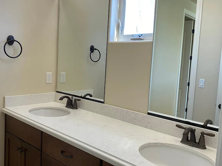 Dual-sink vanity with quartz countertop in the upstairs hall bathroom.