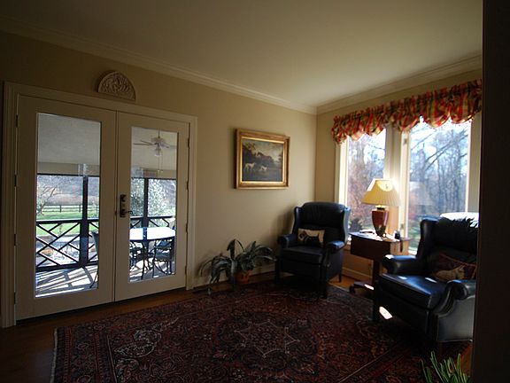 Den located at the rear of the home with access to the screened in porch