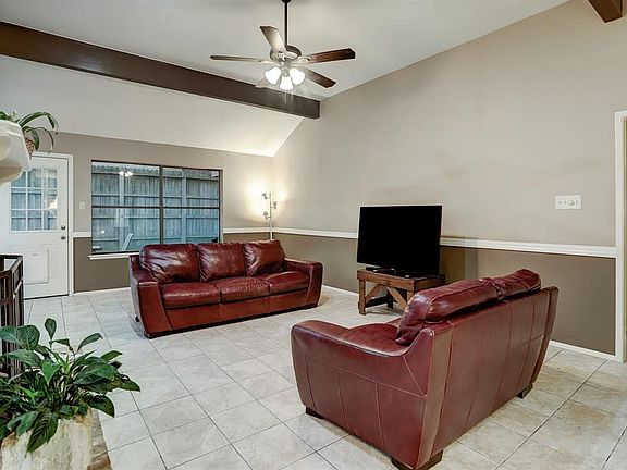 Family Room/Den. 24'x15'. 13"-square stone-like tile floor; chair rail & wainscoting, tan & brown wall color, white ceiling & trim; coffered ceiling with wood beams; wood buring fireplace with brick hearth & surround, wood mantel, gas line, gas logs 