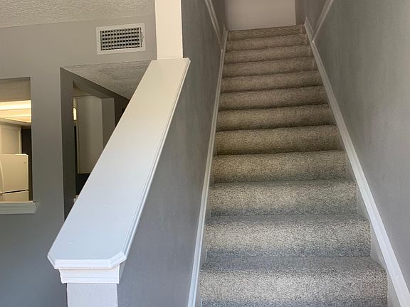Hallway to upstairs and partial view of dining room into kitchen