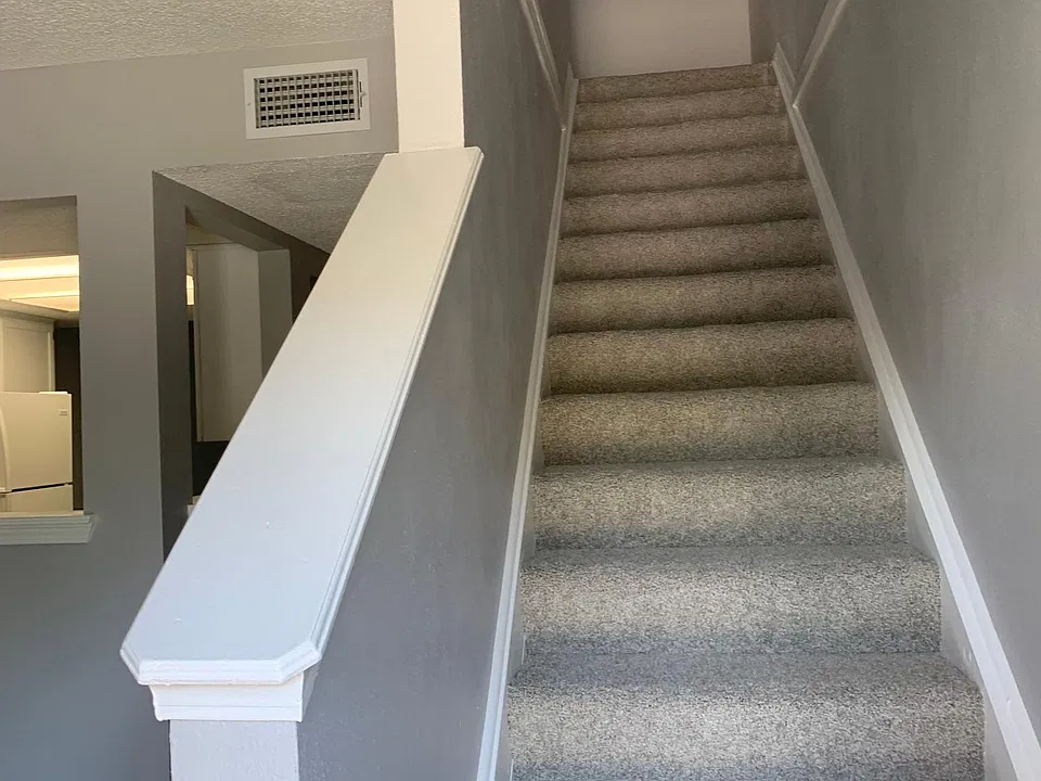 Hallway to upstairs and partial view of dining room into kitchen