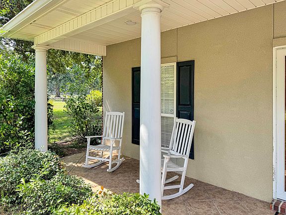 Charming front porch with classic columns, perfect for relaxing outdoors and enjoying the peaceful surroundings.