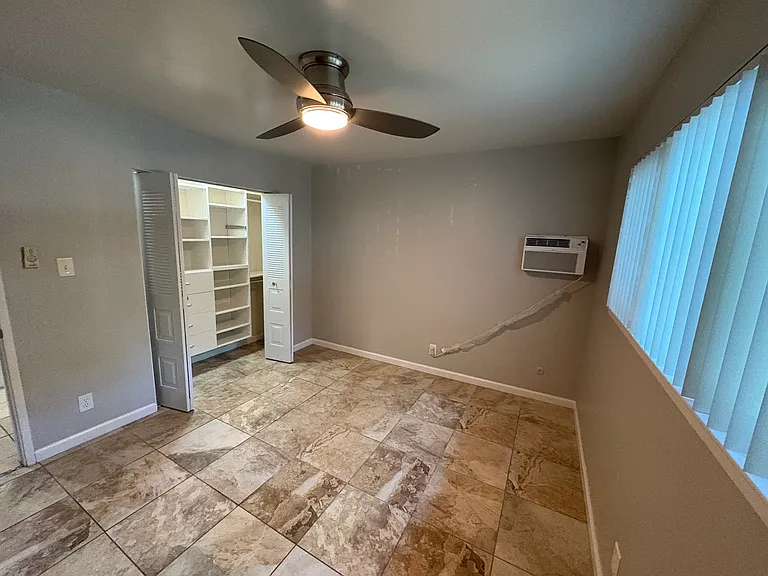 Master bedroom with beautifully organized closet and contemporary tile