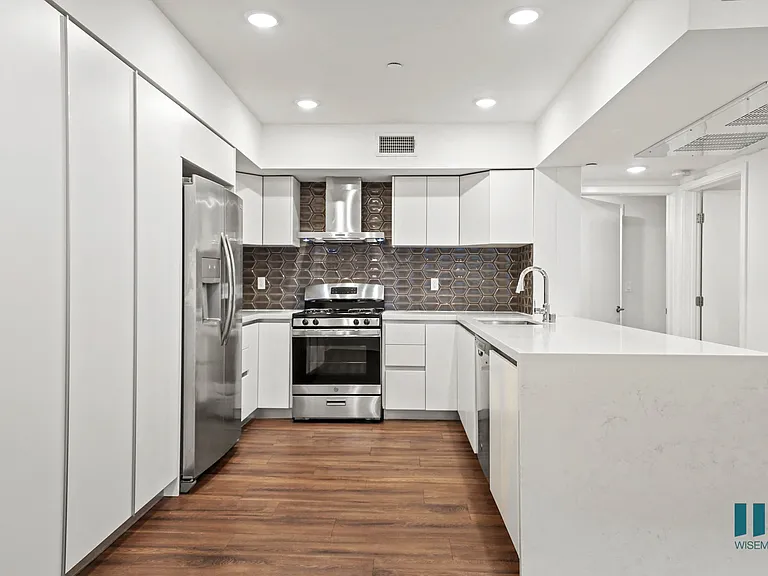 Kitchen with Stainless-Steel Refrigerator, Stove, Dishwasher, and Countertop Bar