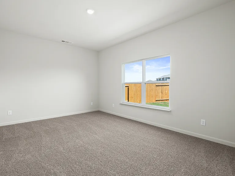 The master bedroom is spacious and has a large window that lets in great, natural light and backyard views.