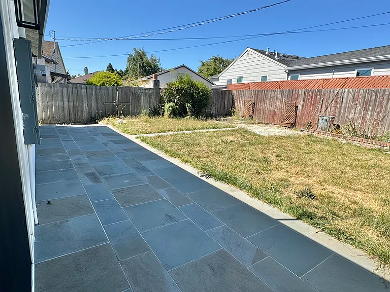 Spacious backyard patio with bluestone pavers