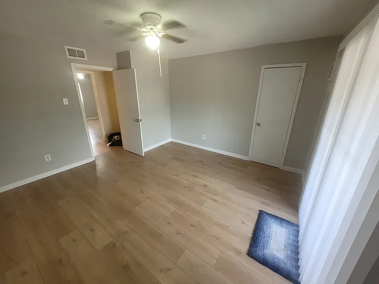 Inside view of street-facing (left from the stairs) bedroom, one closet (right door) and balcony