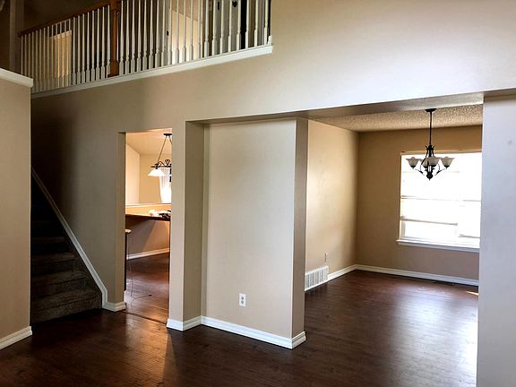 View from living room into kitchen and dining room. Stairs on left lead to master bedroom and two additional upper level bedrooms