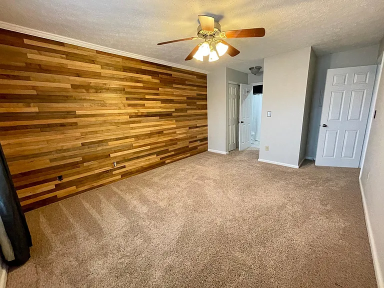 Spacious master bedroom with a gorgeous wood accent wall and ensuite bathroom.