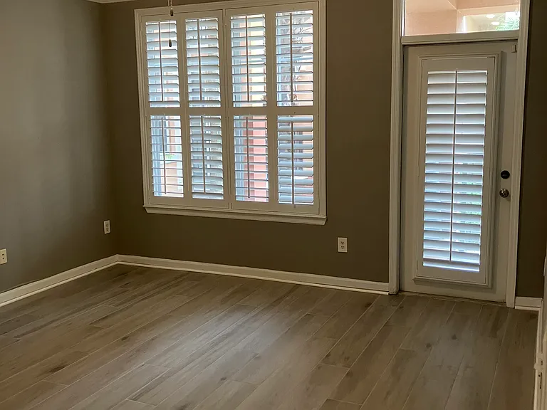 Living room with plantation shutters and remote control fan