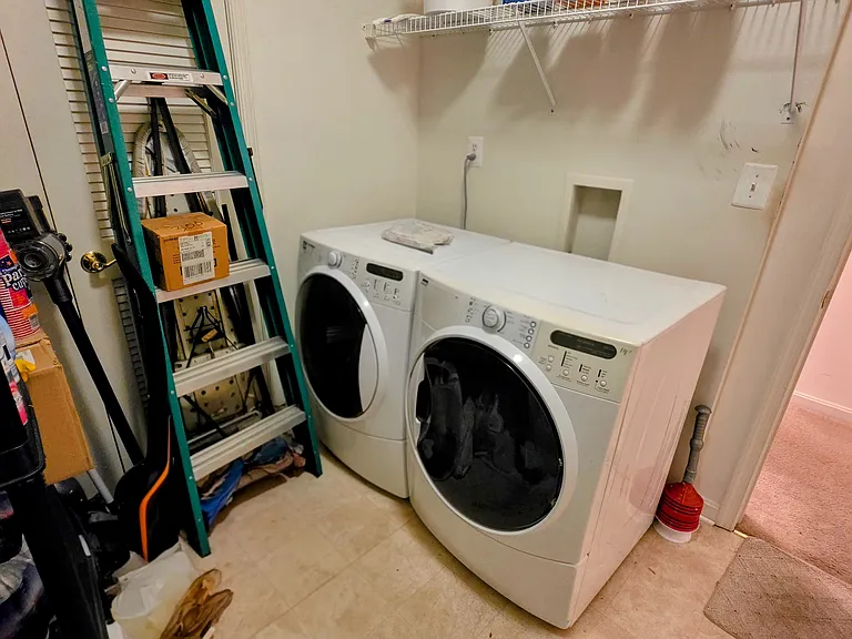Convenient in-unit laundry room equipped with high-efficiency, front-loading washer and dryer plus overhead storage shelving.