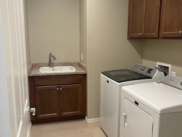 Separate laundry room, sink and upper cabinets right off door to garage. Extra bonus is a laundry room DOOR to close while using the brand new Maytag Washer and Dryer.