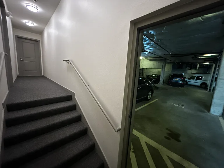 Parking spot for the unit is right in front of the door. We were able to park out 2016 Honda CRV in this spot, but a large truck will not fit. On the left of the photo is the unit entrance at the end of the hall.