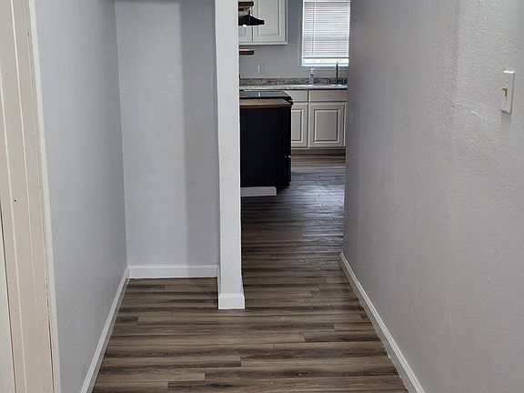 Hall from front to back kitchen. Bath room is to the left and second bedroom is to the right in this picture