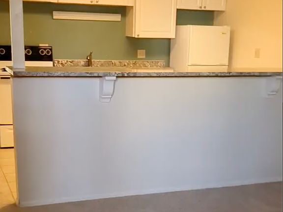 Living room looking onto Kitchen. 
- brand new carpet throughout
-granite counter tops. 
- dishwasher
- fridge/oven, stove 
- Curtains included