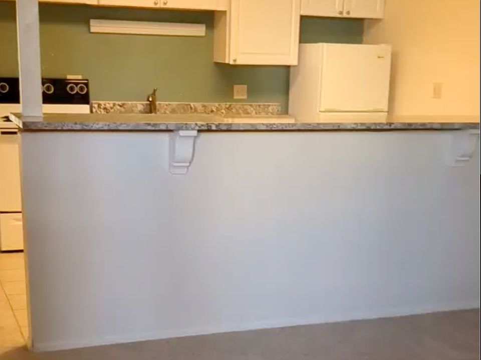 Living room looking onto Kitchen. 
- brand new carpet throughout
-granite counter tops. 
- bar
- dishwasher
- fridge/oven, stove