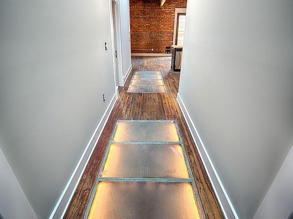 These apts were originally hotel rooms. The interior hallway in this apt was at one time the exterior hallway leading to the hotel rooms. These glass floors once let light from the skylights pass to the floor below. Today they are super cool lighted addit