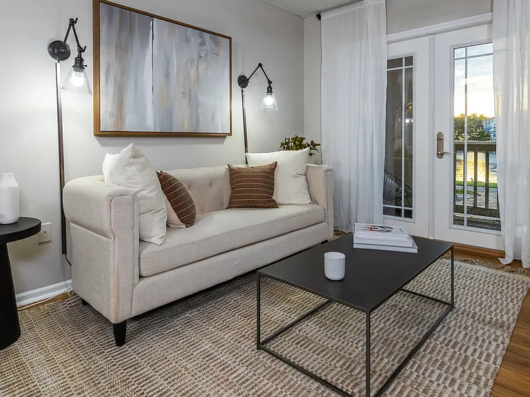 This stylish living room offers a comfortable retreat with modern lighting, and abundant natural light through double glass doors that open to your private patio.