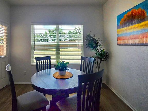 Enjoy the natural light of this charming dining nook, complete with sleek flooring and a vibrant wall canvas, perfect for intimate meals and cozy conversations.