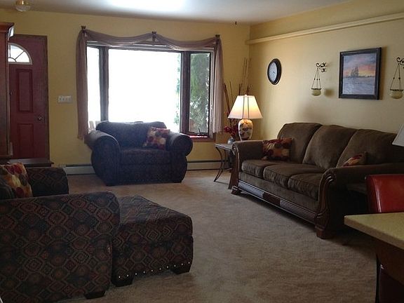 The living room's warm tones allow for instantaneous relaxation.
