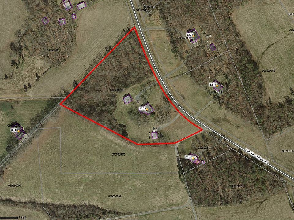 Aerial view showing flat lot w/wooded area.