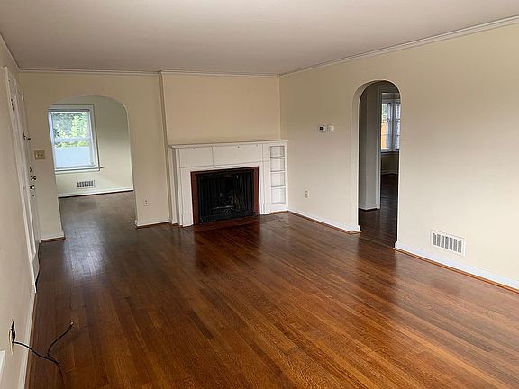 Living room with fireplace; view into separate dining room.