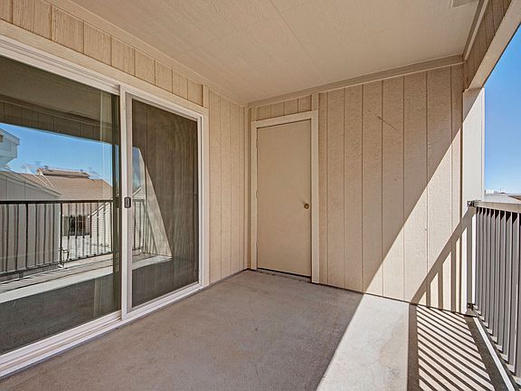 A large balcony with additional storage and a sliding glass door leading to the living room