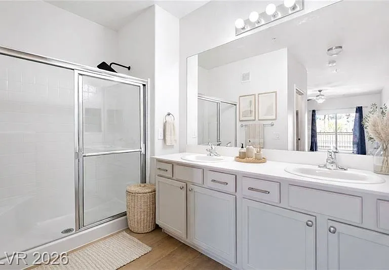 Primary bathroom with double vanities and close door shower