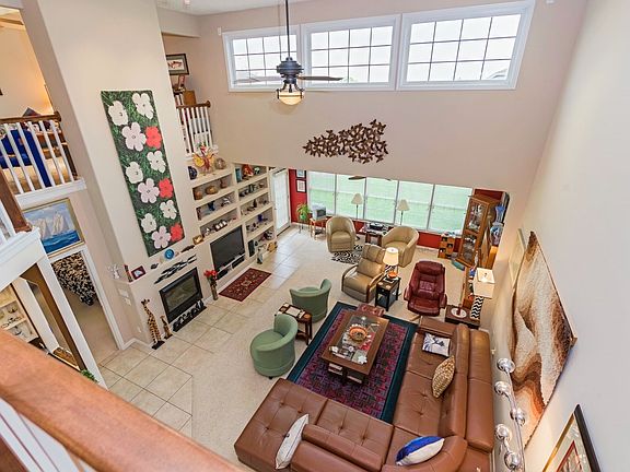 view of two story family room from balcony. Note built in shelving magnificent areas for art display
