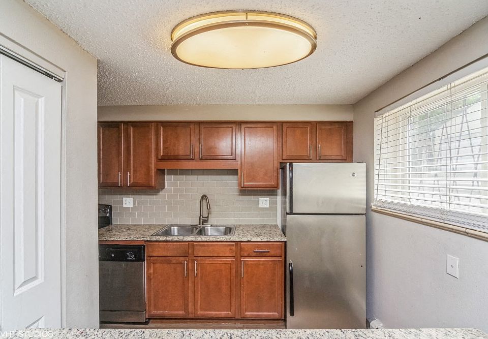 Kitchen with stainless steel appliances and tiled backsplash