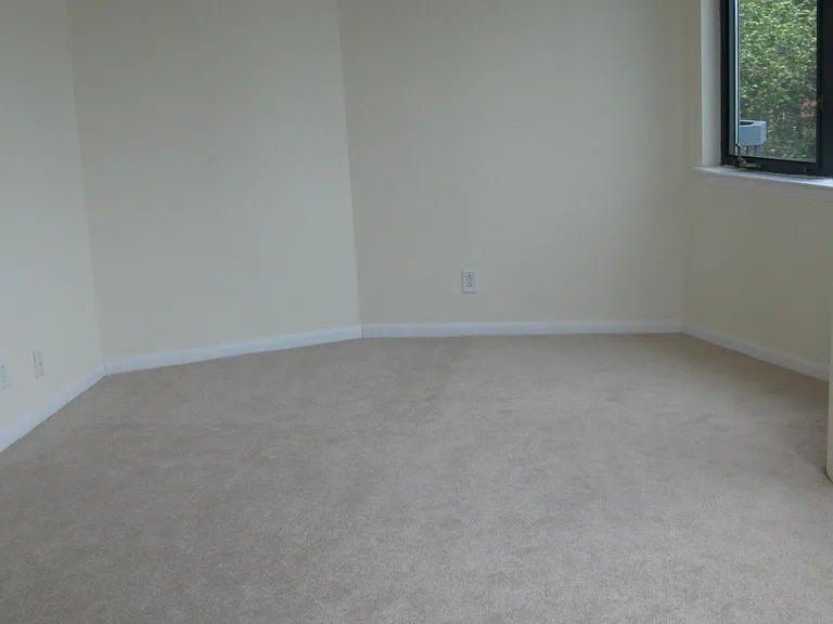 Bedroom with beige wall to wall carpet.