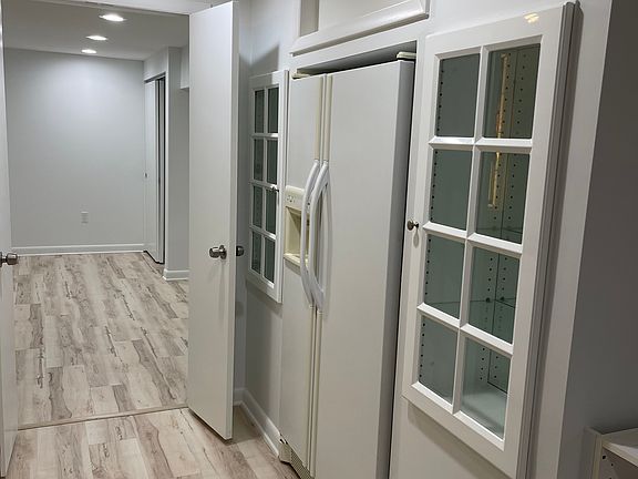 Full size refrigerator with glass cabinets on both sides.
