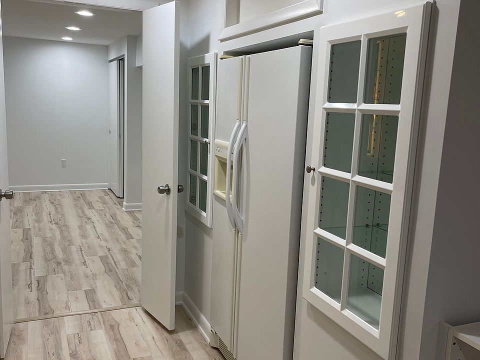 Full size refrigerator with glass cabinets on both sides.