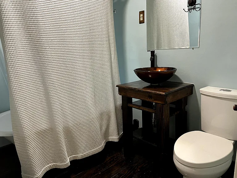 Bathroom with vessel sink and varnished hardwood vanity/floors