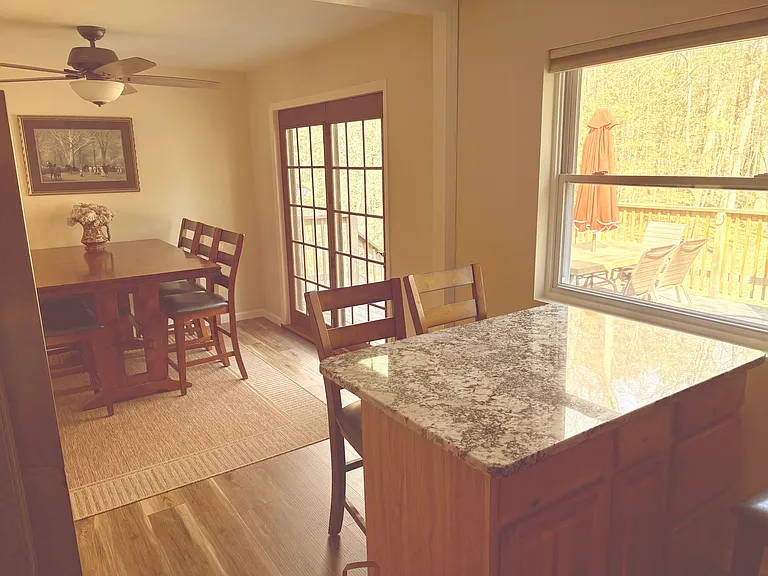 The dining area shares an open_concept layout with the kitchen. Large sliding doors connect the dining room to the deck, and they can be opened to create an effortless indoor_outdoor flow for family and guests