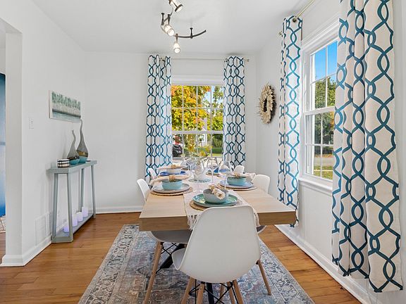 Fresh and inviting_sleek chairs and warm hardwood floors frame a dining table set with beautiful dishes. Near Notre Dame, our South Bend retreat blends style and comfort.