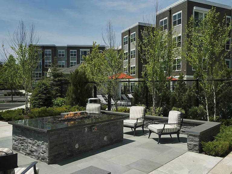 Outdoor Lounge Area with Stone Firepit and Padded Seating