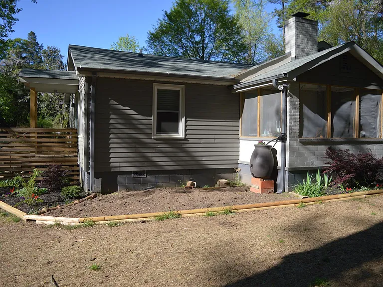 Garden and rain barrel off of screened in porch.