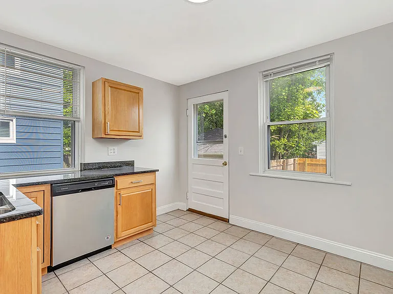 The kitchen has stainless steel appliances, granite countertops, and backyard access.