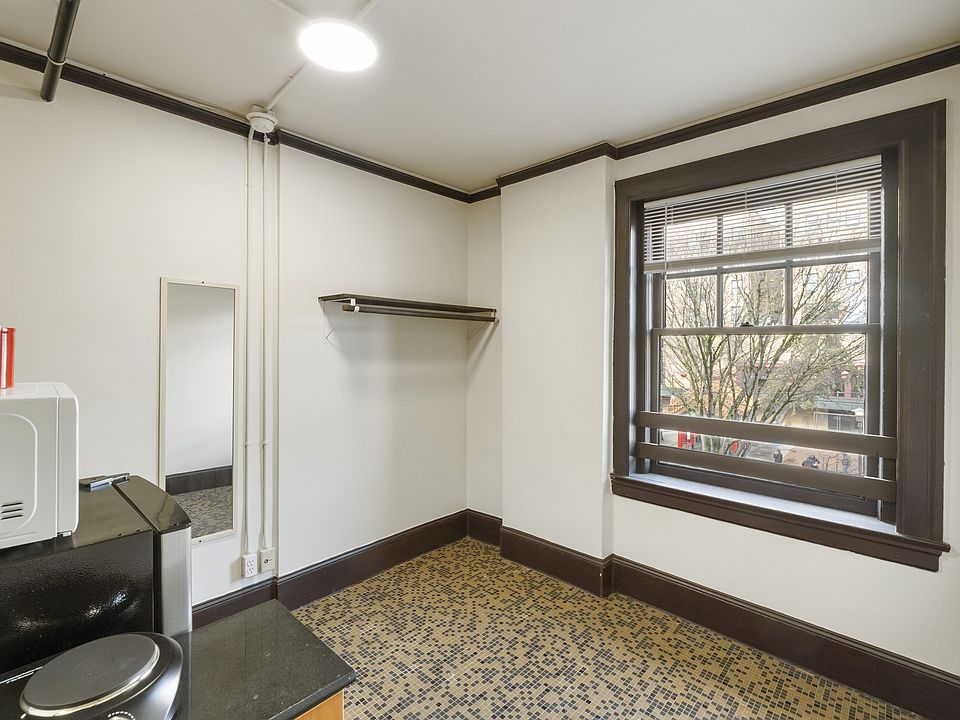 Studio living space with cooking area, refrigerator, microwave