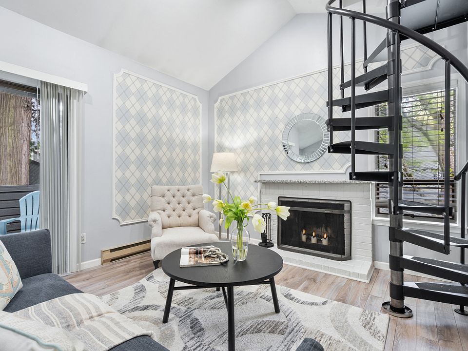 Living room with sliding door to private balcony and spiral stairs to the upper level loft.