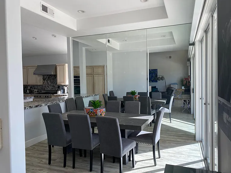 Dining room in front of large windows with views of pool, golf course and mountain range