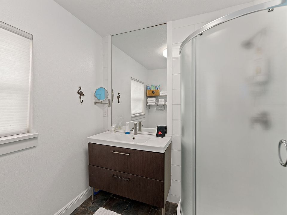 In your short term 1BR Cocoa Beach rental unit bathroom you'll enjoy a full-size sink with compact shower.